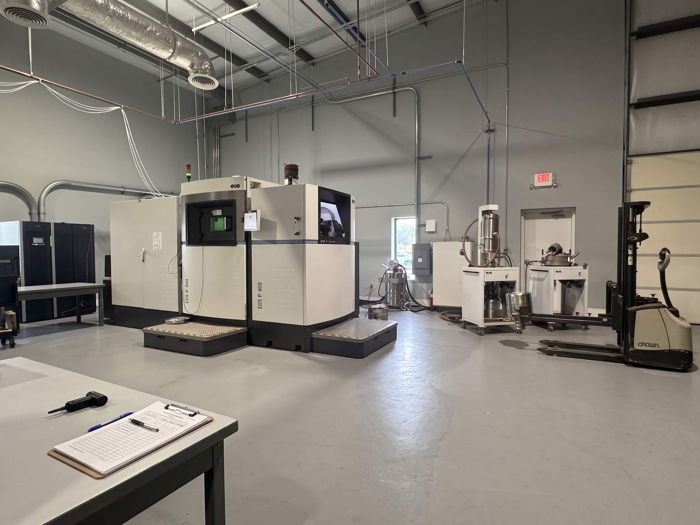 The AME shop floor in Huntsville, with the EOS M 400 metal 3D printer, powder handling station and an inspection bench in the foreground